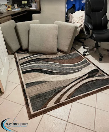 Patterned brown and blue area rug cleaned on a tile floor beside a sofa